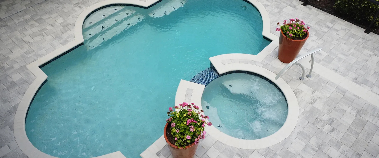 Flagstone Pavers Victory White/Pewter pool deck with a spa